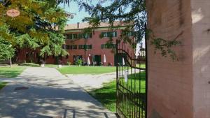 un edificio con cancello di fronte a un edificio di Hotel La Corte a Correzzola