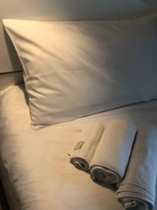 - deux serviettes sur un lit avec un oreiller dans l'établissement Casa Lalla, à Turin