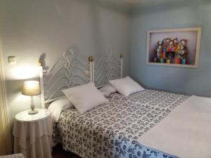 1 dormitorio con 1 cama y una foto en la pared en Casa Rural Luna, en Candeleda