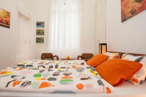a bed with a colorful comforter in a bedroom at Ariel Studio Close to St. Stephen Basilica in Budapest