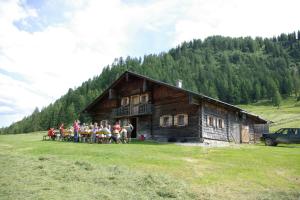grupa ludzi stojących przed kabiną w obiekcie Steinbachgut w mieście Flachau