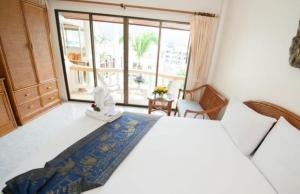 a bedroom with a large bed and a large window at Palmview Resort in Patong Beach