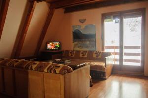 a living room with a couch and a sliding glass door at Rooms Apartment Durmitor in Žabljak
