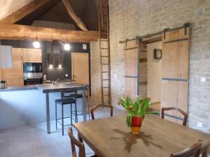 eine Küche und ein Esszimmer mit einem Holztisch in der Unterkunft Chambres d'hôtes Béred Vuillemin in Baume-les-Dames