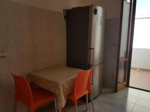 una camera con tavolo, 2 sedie e frigorifero di Casa vacanza Andrea a Porto Cesareo