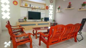 a living room with two chairs and a table and a television at Tangkak Greenville Homestay in Tangkak