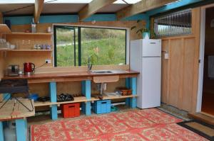 a kitchen with a sink and a refrigerator at First Light Rangihaeata Retreat in Takaka