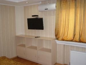 een kamer met een televisie aan een muur met een plank bij Sadok in Kiev