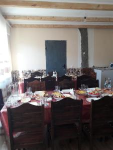 a dining room with a table and chairs with plates and wine glasses at Betegi Guest House in Mestia +28 photos