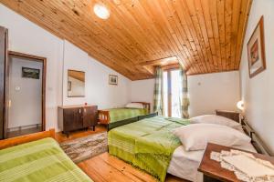 a bedroom with two beds and a wooden ceiling at Apartments and Rooms Ana Pomer 217 in Pomer