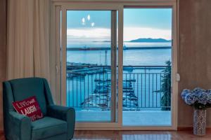 sala de estar con silla y vistas al agua en Jetties & Moorings central apt en Kavala