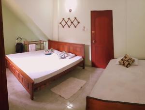 a bedroom with two beds and a red door at Staykandy in Kandy