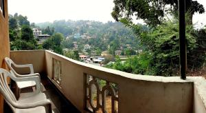 a balcony with chairs and a view of a city at Staykandy in Kandy