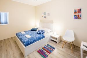 Schlafzimmer mit einem Bett, einem Schreibtisch und einem Stuhl in der Unterkunft Dominic Apartments in Lwiw