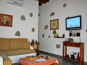 a living room with a couch and a flat screen tv at Casa rural El Coronel in Tejeda