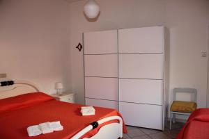 a bedroom with a red bed and a large white closet at La casina dell'Annetta in Lido di Camaiore