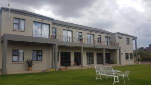 a house with two chairs and a table in the yard at The Anne Guest House in Maseru