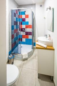 a bathroom with a glass shower and a sink at Dominic Apartments in Lviv