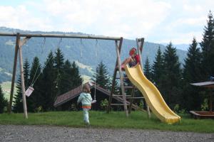 two children playing on a slide at a playground at Friesenhof Blank in Sulzberg