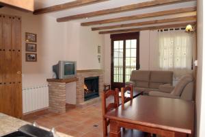 Una sala de estar con una mesa y una chimenea. en Alojamientos Rurales Navahondona, en Arroyo Frío