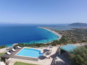 an aerial view of a swimming pool and a beach at Thea Thalatta Villas in Tsoukaladhes