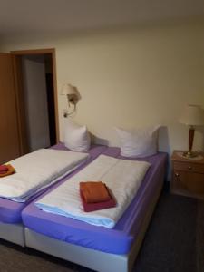 2 camas en una habitación de color púrpura y blanco en Gasthaus ,,Zum schwarzen Bär", en Güsten