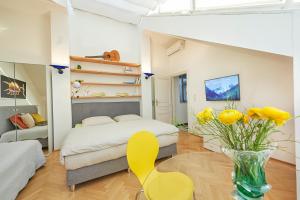 ウィーンにあるPenthouse im❤️Wiensのベッドルーム1室(ベッド1台、黄色い花瓶付)