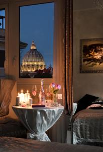 ローマにあるSan Pietro Panoramic Viewのベッドルームにキャンドルとワイングラス付きのテーブル