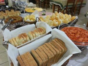 una mesa llena de diferentes tipos de pan y otros alimentos en Hotel Praia Grande, en Penha