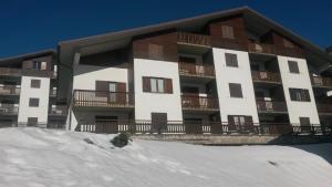 an apartment building with snow in front of it at Genevris in Pragelato