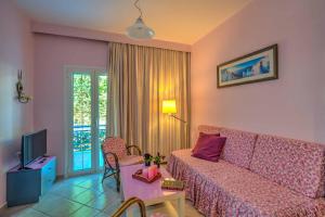 un soggiorno con divano e TV di Elegant 1BR by Heraklion Beach Sun &Comfort Await ad Amoudara Herakliou