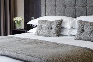 A bed or beds in a room at Killarney Oaks Hotel