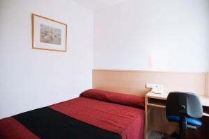 a bedroom with a bed and a desk at Hotel Cim Valles in Santa Perpetua de Moguda