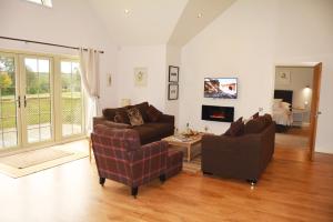 a living room with two couches and a tv at Woodbell Lodge in Chappel