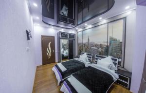 een slaapkamer met een bed en uitzicht op de stad bij Spacious 2 bedroom apartment in Tbilisi City
