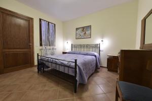 a bedroom with a bed with a purple bedspread at Agriturismo Redipuglia in Alberese