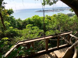 a wooden bridge with a view of the ocean at Kaiza in Nanjo
