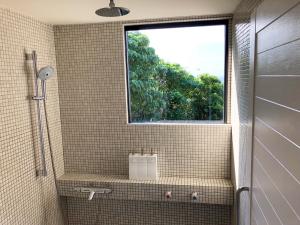 a bathroom with a window and a sink and a shower at Kaiza in Nanjo