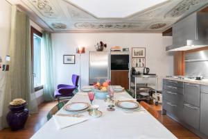 a kitchen with a table with plates and wine glasses at Casa Flavia ai Morosini - Luxury apartment with Canal View in Venice