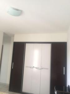 un armario blanco y negro en una habitación en Excelente apartamento de 02 quartos no Privê das Thermas II em Caldas Novas, en Caldas Novas