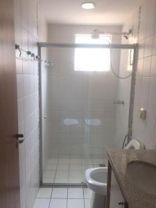 y baño con ducha, aseo y lavamanos. en Excelente apartamento de 02 quartos no Privê das Thermas II em Caldas Novas, en Caldas Novas