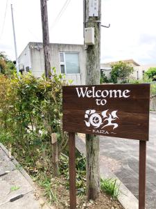 a sign for a welcome to kaza on a street at Kaiza in Nanjo
