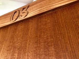 a wooden sign on the side of a building at Kaiza in Nanjo