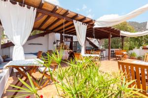 a patio with a wooden pergola and chairs at Kalkan Turk Evi in Kalkan
