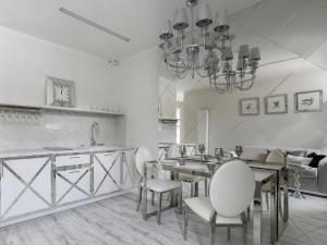 a kitchen with a table and chairs and a chandelier at Sweet Suite in Gdańsk