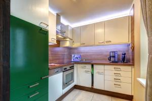eine Küche mit grünen und weißen Schränken und Geräten in der Unterkunft Ferienwohnung Düne 25/1 in Zinnowitz