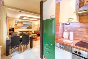 eine Küche mit grünen Schränken und einem Esszimmer in der Unterkunft Ferienwohnung Düne 25/1 in Zinnowitz