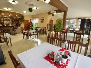 un restaurante con una mesa blanca con un arco rojo. en Zajazd Sum, en Szczyrk