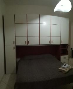 パヴィアにあるScarponeのベッドルーム1室(ベッド1台、白いキャビネット付)