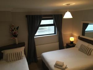 a bedroom with two beds and a window at The Midway Bar & Guesthouse in Dungloe
